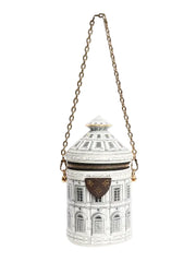 Decorative cylindrical container with architectural design and gold chain on a white background