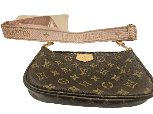 Louis Vuitton handbag with monogram pattern and pink strap on a white background