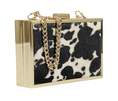 Clutch bag with cow print and gold chain on a white background