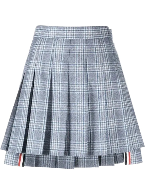 A pleated plaid mini skirt in gray, white, and light blue, featuring a signature red, white, and blue stripe detail along the hem.
