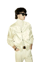 Person wearing a white outfit with a helmet and goggles, possibly in a fencing or equestrian setting.