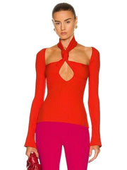 Model wearing a red ribbed top with a cutout design and pink pants on a white background
