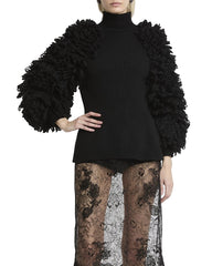 Black sweater with textured sleeves worn by a person on a white background