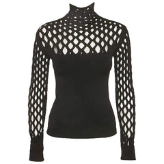 A black long-sleeve mock neck knit sweater featuring an open lattice pattern across the chest and sleeves, displayed on a ghost mannequin against a light gray background.