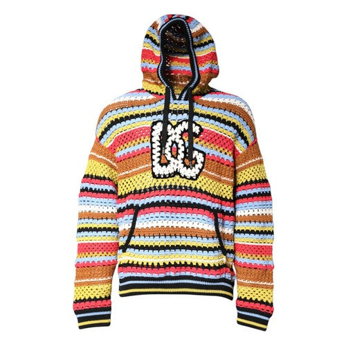 A colorful crocheted hoodie with horizontal stripes in yellow, orange, red, pink, blue, and black, featuring a large white and black crochet 'DC' logo on the chest.