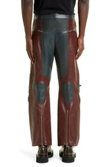 Brown leather pants with gray patches worn by a person on a white background