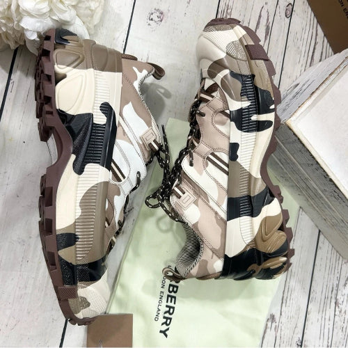 Camouflage-patterned shoes on a white wooden floor with a Burberry box.