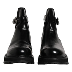 Pair of black leather boots with buckle details on a white background