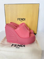 Pink wedge sandal on a Fendi branded surface with a yellow Fendi box in the background.