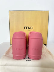 Pink Fendi slippers with a gold Fendi box in the background