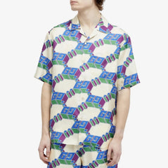 Person wearing a patterned shirt with geometric design on a white background