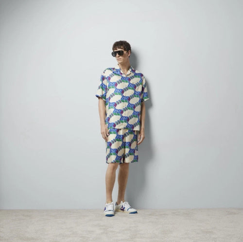 Person wearing a colorful patterned outfit against a plain background