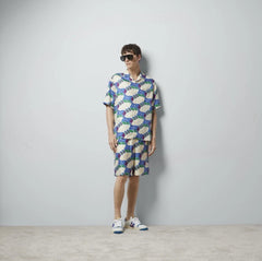 Person wearing a colorful patterned outfit against a plain background