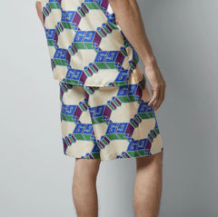 Person wearing a patterned outfit with geometric design on a plain background