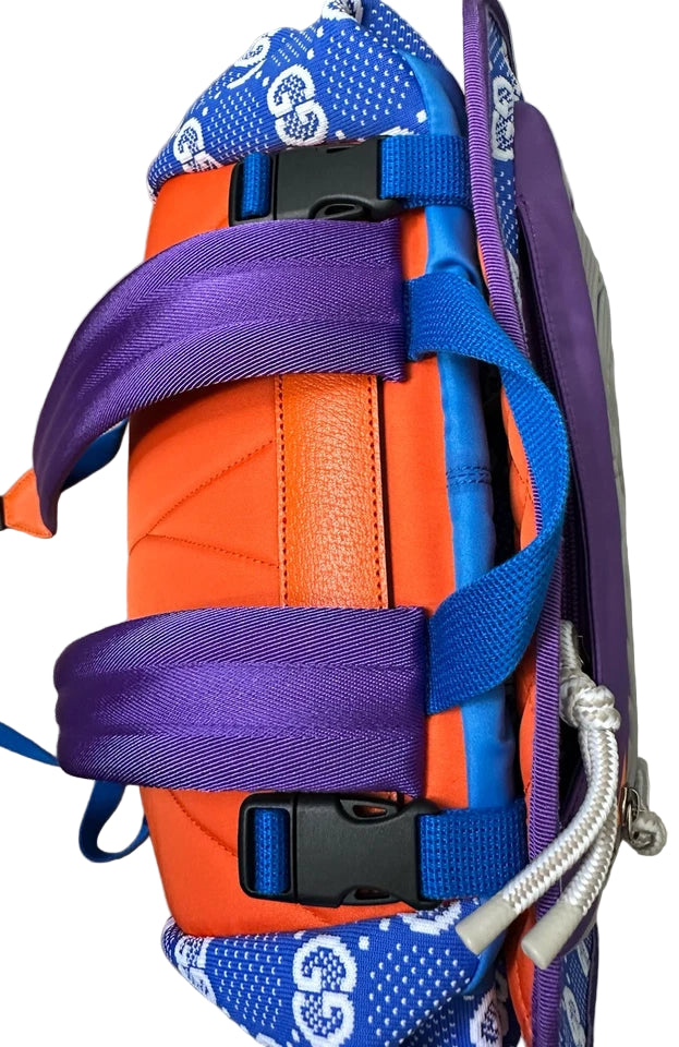 Orange and purple bag with blue straps on a gray surface