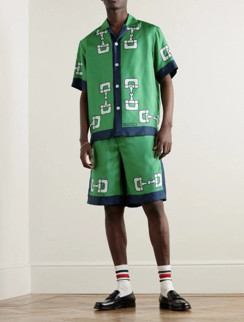 Person wearing a green patterned outfit with matching shoes and socks on a plain background