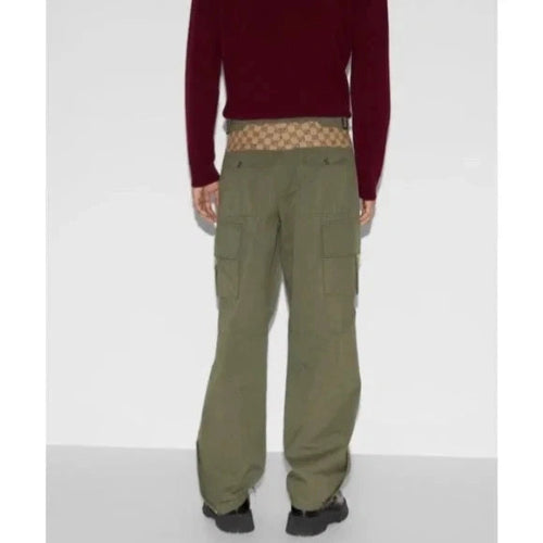 Person wearing green cargo pants with a red sweater and patterned underwear on a white background