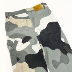 Camouflage-patterned pants with a patch on a plain background