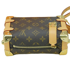 Designer handbag with monogram pattern and gold accents on a white background