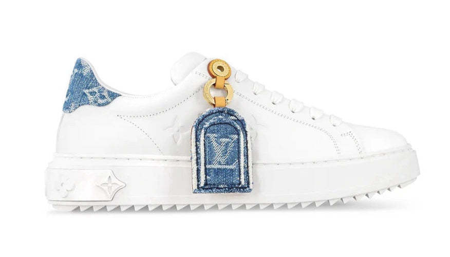 White sneaker with denim patches and gold accents on a white background