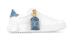 White sneaker with denim patches and gold accents on a white background