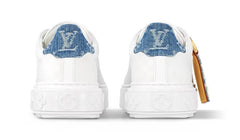 White sneakers with blue denim accents on a white background