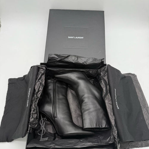 Black high-heeled boots in a Saint Laurent box on a white background