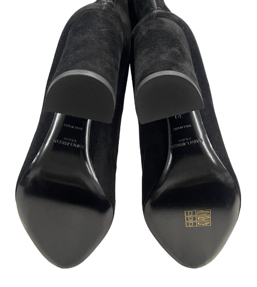 Black suede shoes with brand logo on a light gray background