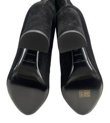 Black suede shoes with brand logo on a light gray background