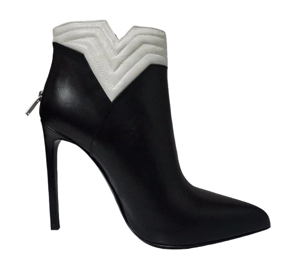 Black high-heeled boot with white quilted design on a gray background