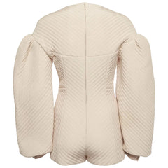 A cream-colored quilted jacket with dramatic puffed sleeves, shown from the back against a light gray background.
