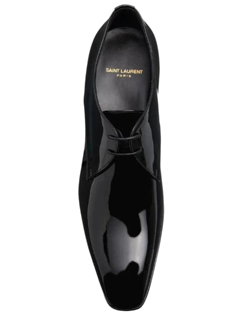 A single Saint Laurent black patent leather oxford shoe shown from a top-down perspective against a light gray background.