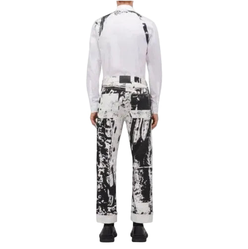 A model shown from the back wearing a white long-sleeve top with black suspenders and black-and-white patterned pants, set against a plain white background.