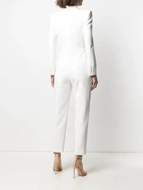 Person wearing a white long-sleeve dress against a white background