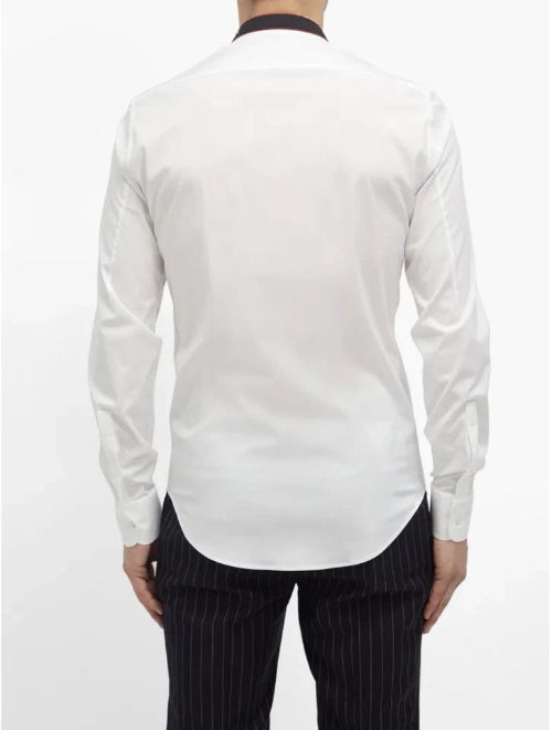 White dress shirt with long sleeves and black pinstripe pants on a white background