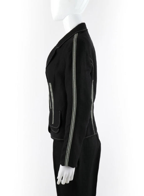 A black one-shoulder dress with a prominent silver zipper running down the front and a white bow detail at the hem, displayed on a white mannequin against a white background.