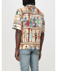 Person wearing a colorful patterned shirt with a neutral background
