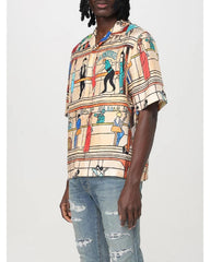 Person wearing a colorful patterned shirt with a neutral background
