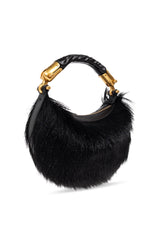 A black fur crescent handbag with a braided leather handle and gold-tone hardware, shown on a plain white background.