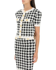 Black and white houndstooth pattern dress with yellow buttons on a white background