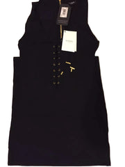 Black sleeveless dress with gold buttons on a textured surface