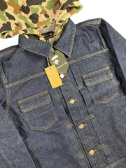 Blue denim jacket with a brand tag on grass