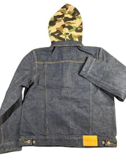 Blue denim jacket with a camouflage hood on a green grass background