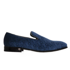 A single navy blue suede slip-on loafer with an embossed monogram pattern, shown in profile against a plain white background.