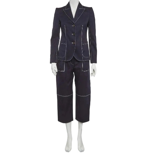 A dark navy blue two-piece suit with contrasting light piping and gold buttons, displayed on a white mannequin against a light gray background.