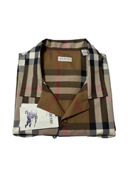 A folded Burberry check shirt jacket in brown, beige, and black, with a brown collar and a white Burberry brand tag visible.