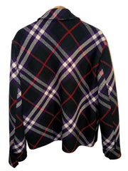 A black and red plaid flannel shirt jacket with white and yellow stripes, hanging on a wooden hanger against a neutral background.