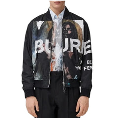A man wearing a black bomber jacket with a large graphic print on the front that reads 'BURE' and 'HISTORIC'.