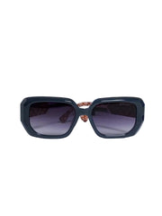 Black square sunglasses with dark lenses, displayed on a white pedestal with a blue patterned box in the background.
