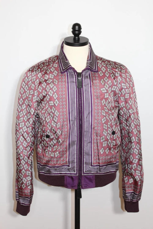 A pink and purple patterned bomber jacket displayed on a black dress form mannequin against a white background.